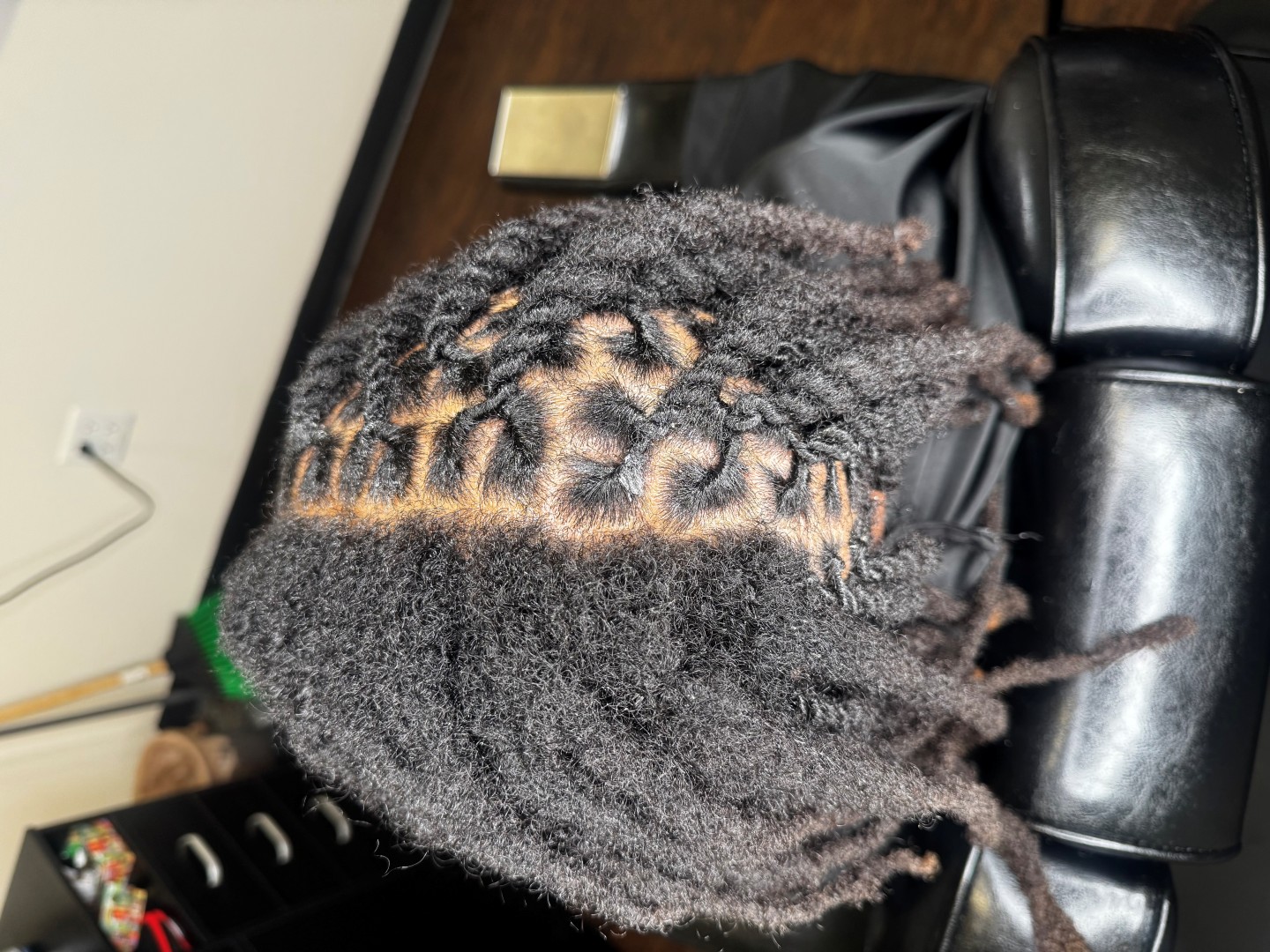 woman in a salon chair in the process of turning her hair to locs