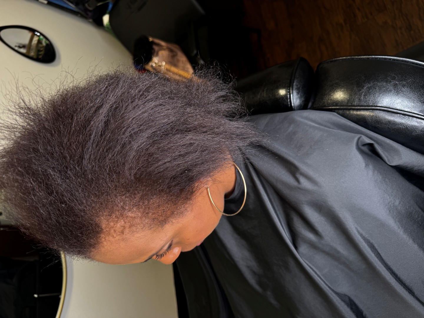 woman with frizzy hair in a salon chair